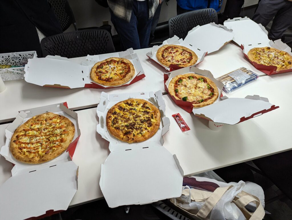 長机の上に６枚のピザが並べられている。